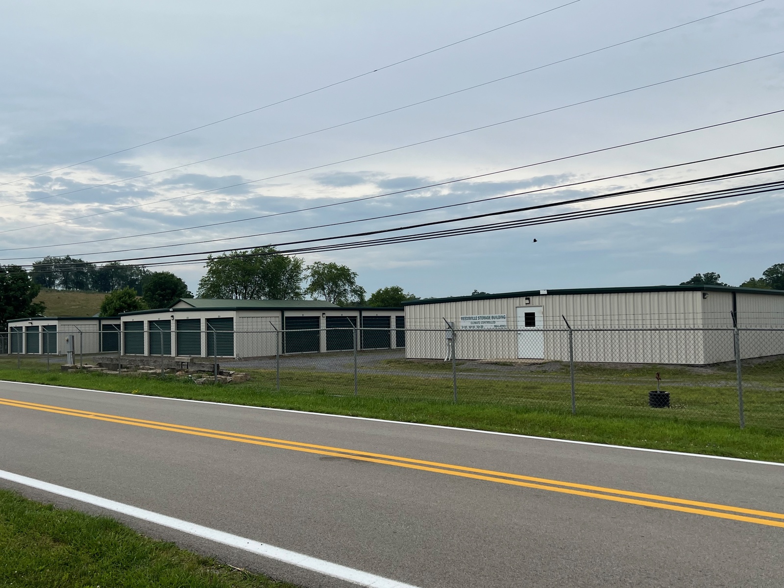 Row of traditional storage units with green roll-up doors